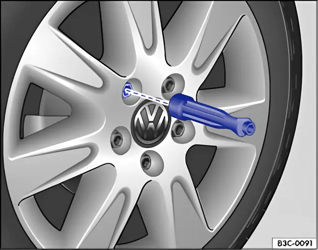 Fig. 172 Changing the wheel: removing the wheel bolts with the screwdriver handle