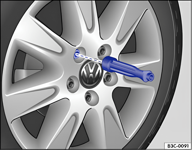 Fig. 172 Changing the wheel: removing the wheel bolts with the screwdriver handle